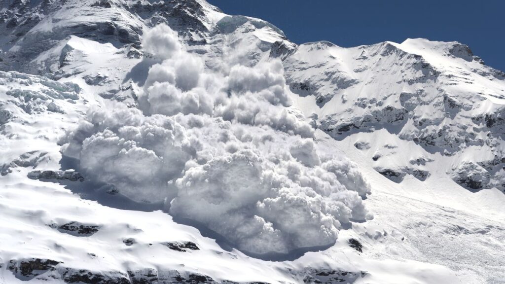 photo of an avalanche hurtling down a snowy mountainside toward the camera